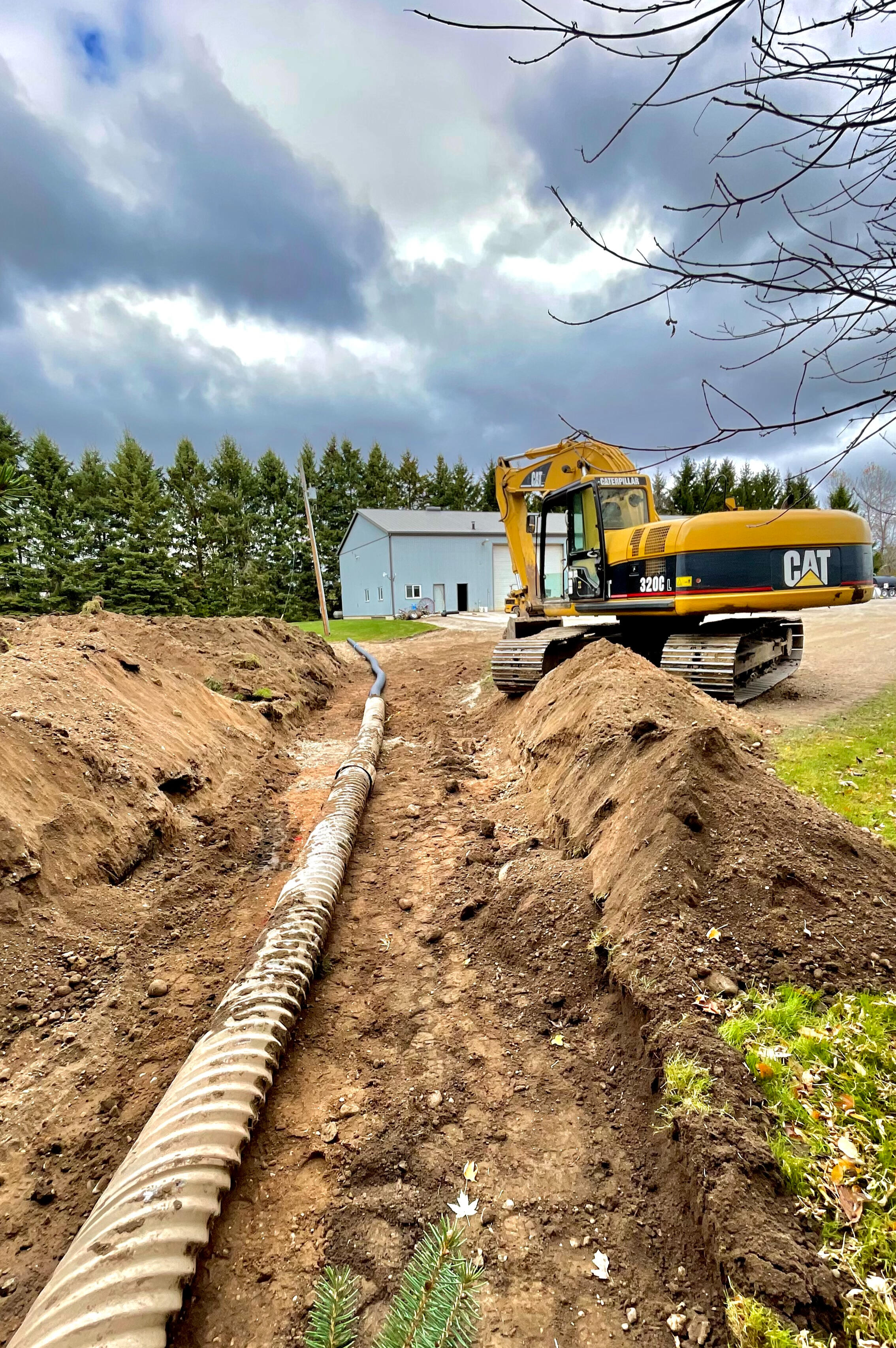 Skid steer performing grading and drainage of a residential house lot in Puslinch, Ontario
