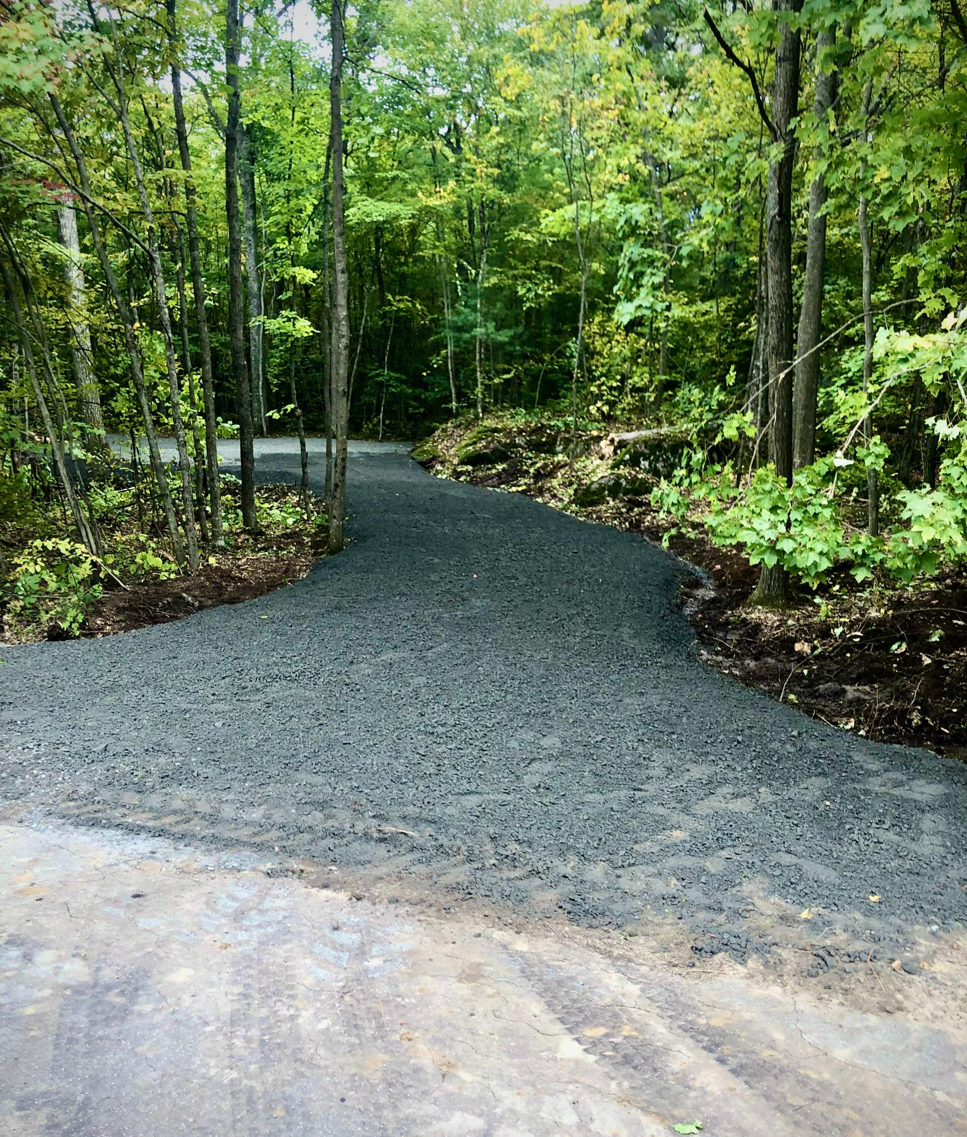 Gravel driveway grading with bulldozer and skid steer for residential property in Waterloo, Ontario